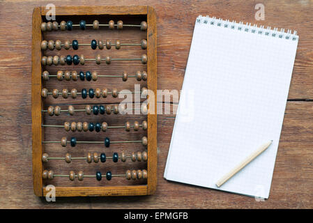 Abacus mit Notizblock und Bleistift auf Vintage Holztisch Stockfoto