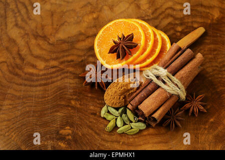 duftende Zimtstangen, Sternanis, Kardamom und Orange auf einem hölzernen Hintergrund Stockfoto
