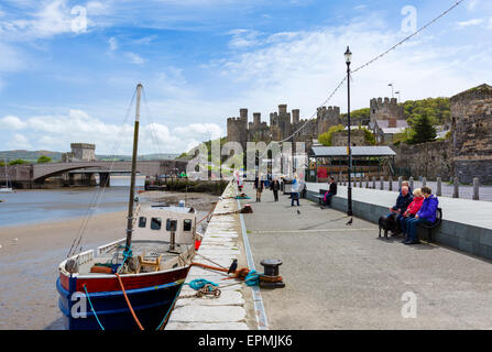 Niedriger Gate Street mit Conwy Castle in der Ferne, Conwy, North Wales, UK Stockfoto