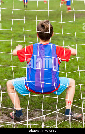 Ein kleiner Junge spielt im Tor für seine Fußball-Nationalmannschaft Stockfoto