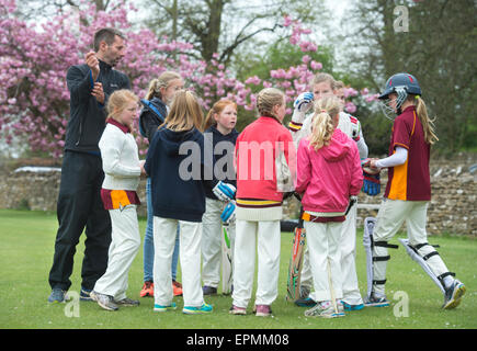 Junior Mädchen bereiten für ein Cricket-Match mit ihrem Trainer in Wiltshire, England Stockfoto