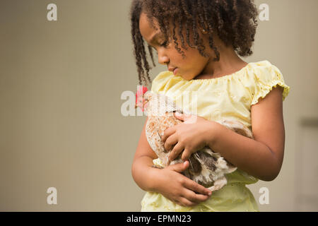 Ein junges Mädchen, ein Huhn auf dem Arm halten. Stockfoto