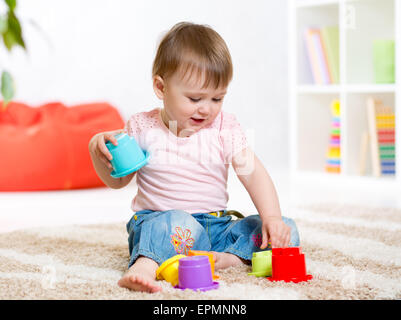 junge Mädchen spielen mit Spielzeug drinnen Stockfoto