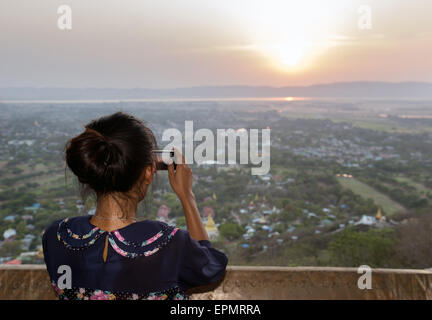 Junge Frau fotografieren Sonnenuntergang Stockfoto