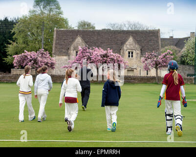 Junior Mädchen nehmen Sie in das Feld für ein Cricket-Match mit ihrem Trainer in Wiltshire, England Stockfoto