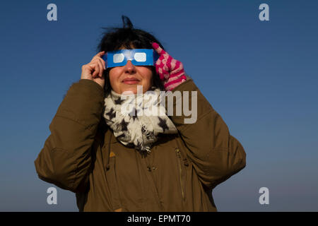 Frau, die gerade der sensationelle partielle Sonnenfinsternis, 20. März 2015, am Moor, Halbinsel Gower, Wales, UK Stockfoto