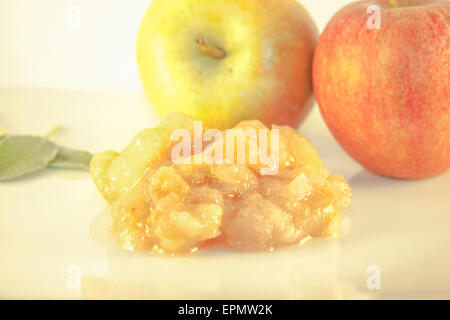 Ein Haufen von Apfelkonfitüre vor Apple und Kräuter Stockfoto
