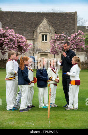 Junior Mädchen bereiten für ein Cricket-Match mit ihrem Trainer in Wiltshire, England Stockfoto