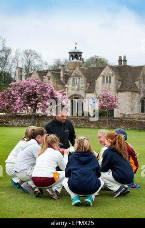 Junior Mädchen bereiten für ein Cricket-Match mit ihrem Trainer in Wiltshire, England Stockfoto