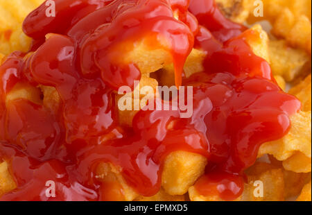 Ganz in der Nähe Blick auf knusprige Pommes frites bedeckt mit Ketchup. Stockfoto