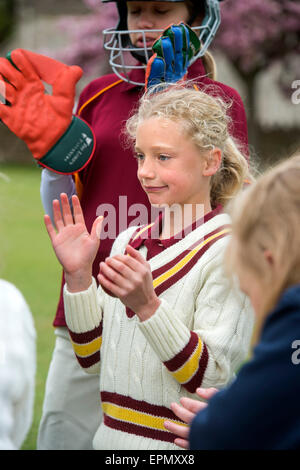 Junior Mädchen feiern Einnahme einer Pforte während ein Cricket-Match in Wiltshire, England Stockfoto