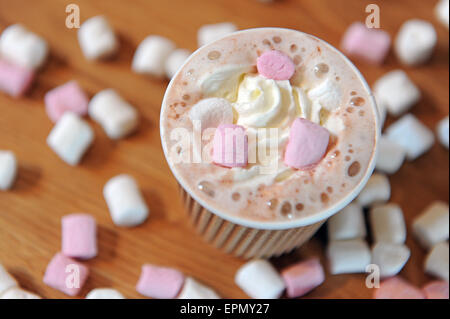 Studioaufnahme von Braun dreifach Liniertes Papier Kaffee Tasse gefüllt mit heißer Schokolade, Sahne und Mini-Marshmallows. Stockfoto