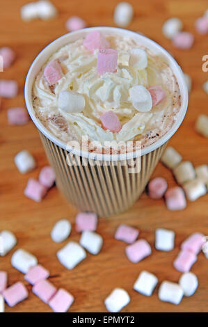 Studioaufnahme von Braun dreifach Liniertes Papier Kaffee Tasse gefüllt mit heißer Schokolade, Sahne und Mini-Marshmallows. Stockfoto