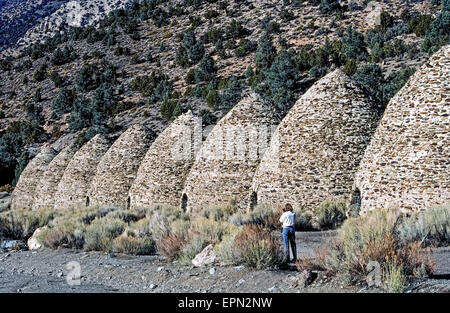 Ein Tourist fotografiert, einige der historischen Bienenstock-förmigen Kohlen Öfen gebaut im Jahre 1877 zu Kohle für Erz schmelzen verwendet in Silber und Blei-Bergbau in der Nähe von Death Valley, Kalifornien, USA. Stein und Mörtel Strukturen wurden Wildrose Canyon in den Panamint Mountains in der Nähe von Holz gebaut, die Kiefern und Wacholder-Bäume, die langsam verbrannt wurden, für eine Woche enthalten, um die Kohle zu erstellen. Die 10 Öfen wurden aufgegeben, als die Minen stillgelegt aber ein Jahrhundert später restauriert wurden und eine Attraktion im Death Valley National Park geworden. Stockfoto