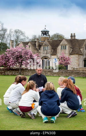 Junior Mädchen bereiten für ein Cricket-Match mit ihrem Trainer in Wiltshire, England Stockfoto