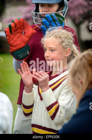 Junior Mädchen feiern Einnahme einer Pforte während ein Cricket-Match in Wiltshire, England Stockfoto