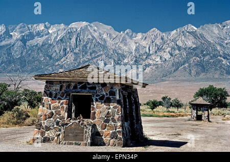 Ein historischer Marker ist vor einem ehemaligen Wachposten am Manzanar, ein zweiter Weltkrieg Umzug Lager montiert, wo mehr als 10.000 japanische Amerikaner zwischen 1942-45 am Fuße der Berge der Sierra Nevada in entfernten Owens Valley im Inyo County, California, USA inhaftiert waren. Umgeben von barbed Wire und Wache Türme, Manzanar war das erste von 10 Kriegszeit Internierungslager für Amerikaner japanischer Abstammung in den Vereinigten Staaten gegründet. Das verlassene Lager ist heute ein National Historic Site und begrüßt die Besucher. Stockfoto