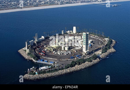 Eine Luftaufnahme zeigt einen der vier künstlichen Inseln wo Ölquellen tätig sind direkt an der Küste in San Pedro Bucht in Sichtweite der Stadt von Long Beach, Kalifornien, USA. Die Neuheit ist, dass die Lagertanks, Bohrtürme, Pumpen und andere notwendige Ausrüstung für Rohöl unter dem Meer extrahieren getarnt und schallisoliert von tropischen Landschaftsgestaltung, Wasserfälle und Gebäudefassaden eine Insel-Resort wie gesehen von der Stadt Küste nachempfunden. Dies ist Insel weiß, benannt nach US-amerikanischer Astronaut Ed White, die umgekommen sind, wenn sein Raumschiff Apollo 1 gefangen im Jahr 1967 Feuer. Stockfoto