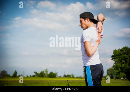 Sportlich, gut aussehend passen jungen Mann im Land, stretching-Übungen im freien Stockfoto