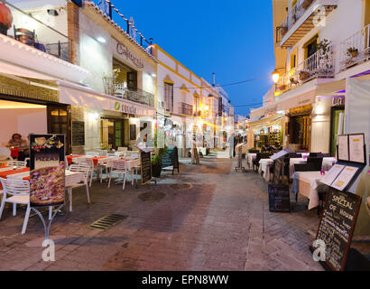 NERJA, MALAGA, Spanien - 18. April 2013: Menschen flanieren bei Sonnenuntergang entlang der Fußgängerzone von Unterhaltungsmöglichkeiten in voll Stockfoto