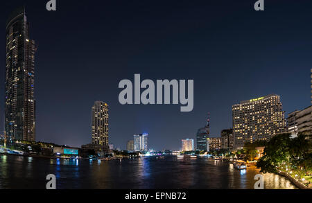 Skyline und Boot auf dem Fluss Mae Nam Chao Phraya, in der Nacht, Bangkok, Thailand Stockfoto