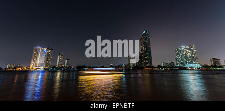 Skyline und Boot auf dem Fluss Mae Nam Chao Phraya, in der Nacht, Bangkok, Thailand Stockfoto