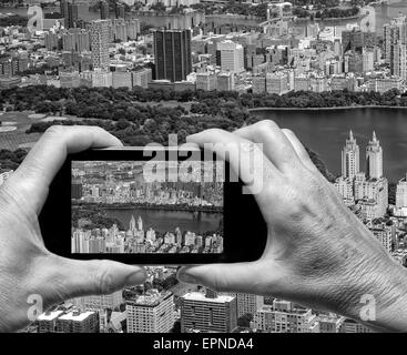 Mann und Frau hand erfassen aerial Skyline von New York mit smartphone Stockfoto