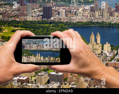 Mann und Frau hand erfassen aerial Skyline von New York mit smartphone Stockfoto