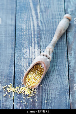 Hirsebrei in Löffel und auf einem Tisch Stockfoto