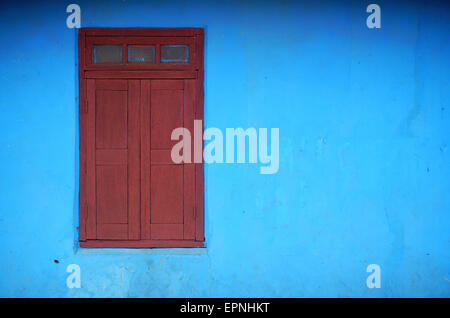 roten Fensterläden Fenster und helle blaue Wand Stockfoto