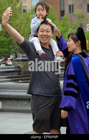 Eine asiatische Familie NYU eine Selfie nach dem Studium der Mutter wegzunehmen. Im Washington Square Park in New York City Stockfoto