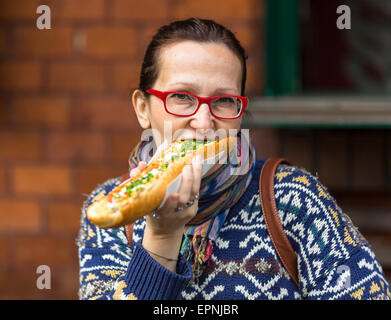 Junge Frau Essen polnische Fast-Food-Auflauf (Zapiekanka) Stockfoto