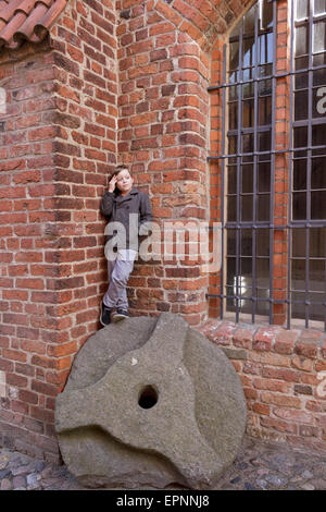 kleiner Junge steht auf einem alten Mühlrad Beim Johanniskloster, Stralsund, Mecklenburg-West Pomerania, Deutschland Stockfoto