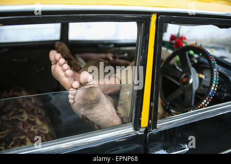 Taxifahrer ohne einen Passagier Tarif nimmt ein Nickerchen / sleep in sein Taxi in Mumbai / Bombay, Indien Wirtschaftsmetropole und Hauptstadt o Stockfoto