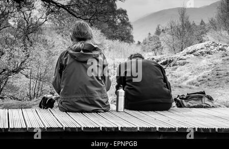 Zwei Wanderer Picknicken auf der Brücke über den oberen fällt der Aira Beck, über Aria Kraft, in der Nähe von Ullswater, Lake District, Cumbria Stockfoto