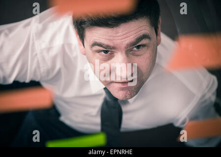 Geschäftsmann Glaswand mit Klebstoff Noten blickte. Konzeptbild von Business-Planung und Strategie. Stockfoto
