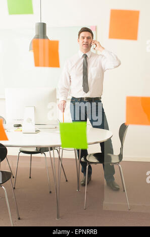 Geschäftsmann Glaswand mit Klebstoff Notizen zu betrachten. Konzeptbild der Unternehmensplanung. Stockfoto