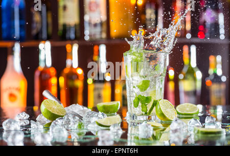 Mojito cocktail Drink mit Spritzen, serviert auf Bartheke mit Unschärfe Flaschen auf Hintergrund Stockfoto