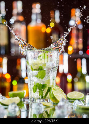 Mojito cocktail Drink mit Spritzen, serviert auf Bartheke mit Unschärfe Flaschen auf Hintergrund Stockfoto