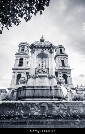 Brunnen und Fassade von Saint-Sulpice, eine römisch-katholische Kirche in Paris, Frankreich. Black And White Vintage stilisierte Foto Stockfoto