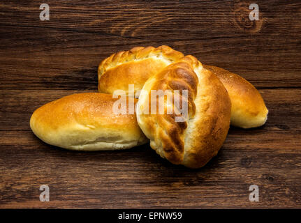 Knusprige weiße Brötchen auf einem hölzernen rustikalen Hintergrund. Stockfoto