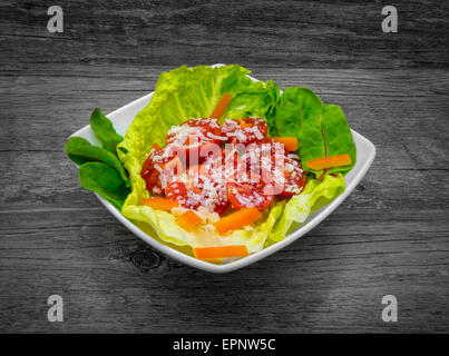 Frischer Salat auf einem rustikalen hölzernen Hintergrund. Stockfoto