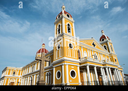 GRANADA, Nicaragua – die Kathedrale von Granada mit ihrem charakteristischen gelb-weißen Äußeren dominiert die Skyline des Parque Central. An dieser Stelle gibt es seit etwa 1525 eine Kirche, die aber in den folgenden Jahrhunderten mehrmals zerstört und wieder aufgebaut wurde, als die Stadt Granada von Piraten und anderen angegriffen wurde. Der Bau der heutigen Version begann 1888, wurde aber erst 1972 vollständig abgeschlossen. Mit seinem markanten Gelb und weißen Zierelementen, steht es über dem Parque Central im Herzen von Granada, Nicaragua. Stockfoto