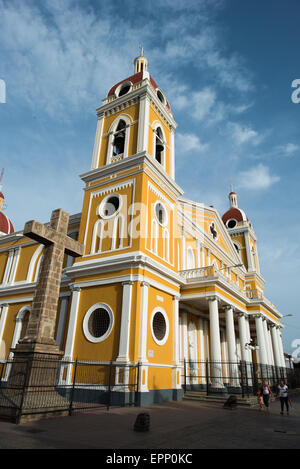 GRANADA, Nicaragua – die Kathedrale von Granada mit ihrem charakteristischen gelb-weißen Äußeren dominiert die Skyline des Parque Central. An dieser Stelle gibt es seit etwa 1525 eine Kirche, die aber in den folgenden Jahrhunderten mehrmals zerstört und wieder aufgebaut wurde, als die Stadt Granada von Piraten und anderen angegriffen wurde. Der Bau der heutigen Version begann 1888, wurde aber erst 1972 vollständig abgeschlossen. Mit seinem markanten Gelb und weißen Zierelementen, steht es über dem Parque Central im Herzen von Granada, Nicaragua. Stockfoto