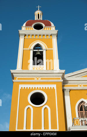 GRANADA, Nicaragua – die Kathedrale von Granada mit ihrem charakteristischen gelb-weißen Äußeren dominiert die Skyline des Parque Central. An dieser Stelle gibt es seit etwa 1525 eine Kirche, die aber in den folgenden Jahrhunderten mehrmals zerstört und wieder aufgebaut wurde, als die Stadt Granada von Piraten und anderen angegriffen wurde. Der Bau der heutigen Version begann 1888, wurde aber erst 1972 vollständig abgeschlossen. Mit seinem markanten Gelb und weißen Zierelementen, steht es über dem Parque Central im Herzen von Granada, Nicaragua. Stockfoto