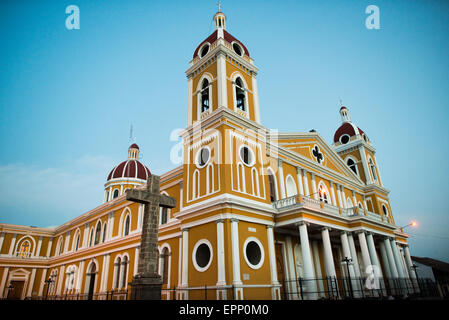 GRANADA, Nicaragua – die Kathedrale von Granada mit ihrem charakteristischen gelb-weißen Äußeren dominiert die Skyline des Parque Central. An dieser Stelle gibt es seit etwa 1525 eine Kirche, die aber in den folgenden Jahrhunderten mehrmals zerstört und wieder aufgebaut wurde, als die Stadt Granada von Piraten und anderen angegriffen wurde. Der Bau der heutigen Version begann 1888, wurde aber erst 1972 vollständig abgeschlossen. Mit seinem markanten Gelb und weißen Zierelementen, steht es über dem Parque Central im Herzen von Granada, Nicaragua. Stockfoto