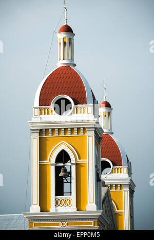 GRANADA, Nicaragua – die Kathedrale von Granada mit ihrem charakteristischen gelb-weißen Äußeren dominiert die Skyline des Parque Central. An dieser Stelle gibt es seit etwa 1525 eine Kirche, die aber in den folgenden Jahrhunderten mehrmals zerstört und wieder aufgebaut wurde, als die Stadt Granada von Piraten und anderen angegriffen wurde. Der Bau der heutigen Version begann 1888, wurde aber erst 1972 vollständig abgeschlossen. Mit seinem markanten Gelb und weißen Zierelementen, steht es über dem Parque Central im Herzen von Granada, Nicaragua. Stockfoto