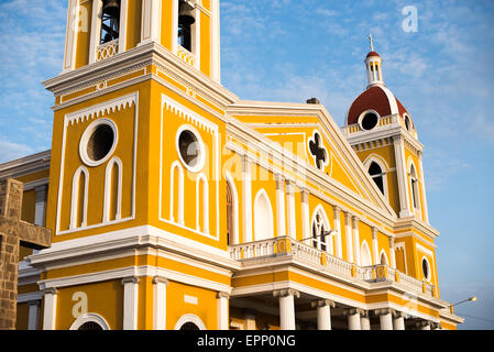 GRANADA, Nicaragua – die Kathedrale von Granada mit ihrem charakteristischen gelb-weißen Äußeren dominiert die Skyline des Parque Central. An dieser Stelle gibt es seit etwa 1525 eine Kirche, die aber in den folgenden Jahrhunderten mehrmals zerstört und wieder aufgebaut wurde, als die Stadt Granada von Piraten und anderen angegriffen wurde. Der Bau der heutigen Version begann 1888, wurde aber erst 1972 vollständig abgeschlossen. Mit seinem markanten Gelb und weißen Zierelementen, steht es über dem Parque Central im Herzen von Granada, Nicaragua. Stockfoto