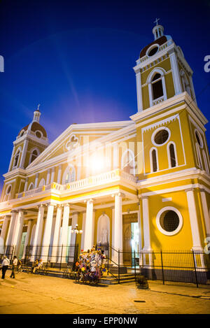 GRANADA, Nicaragua – die Kathedrale von Granada mit ihrem charakteristischen gelb-weißen Äußeren dominiert die Skyline des Parque Central. An dieser Stelle gibt es seit etwa 1525 eine Kirche, die aber in den folgenden Jahrhunderten mehrmals zerstört und wieder aufgebaut wurde, als die Stadt Granada von Piraten und anderen angegriffen wurde. Der Bau der heutigen Version begann 1888, wurde aber erst 1972 vollständig abgeschlossen. Mit seinem markanten Gelb und weißen Zierelementen, steht es über dem Parque Central im Herzen von Granada, Nicaragua. Stockfoto