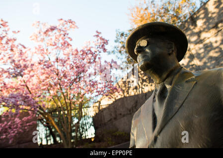 WASHINGTON DC, Vereinigte Staaten – Eine Statue von Franklin Delano Roosevelt am FDR Memorial in Washington DC erstrahlt am frühen Morgen das Licht und im Hintergrund blüht eine Pnik-Tulpenmagnolie. Das Franklin Delano Roosevelt Memorial ist ein weitläufiges Monument, das sich über 7,5 Hektar im West Potomac Park der Hauptstadt erstreckt. Das 1997 eingeweihte Denkmal ist eine Hommage an den 32. Präsidenten der Vereinigten Staaten, FDR, und seinen anhaltenden Einfluss auf die amerikanische Geschichte. Stockfoto